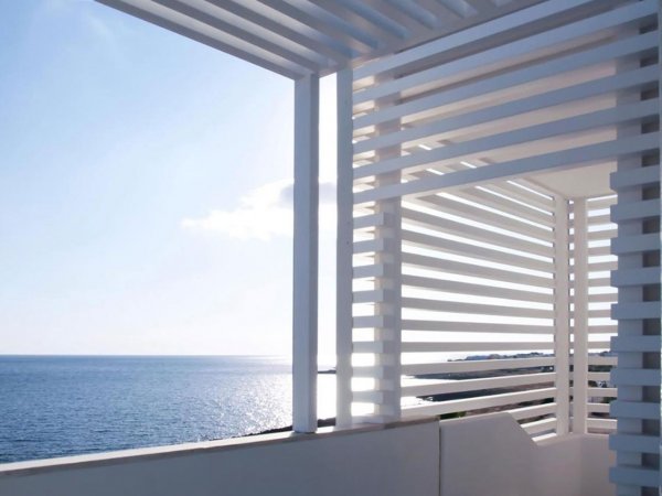 Struttura a griglia bianca su balcone con vista mare.