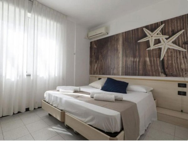 Camera con letto matrimoniale, decorazioni a forma di stelle marine, luce naturale.