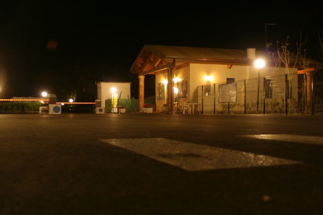 Edificio illuminato di sera su una strada asfaltata.