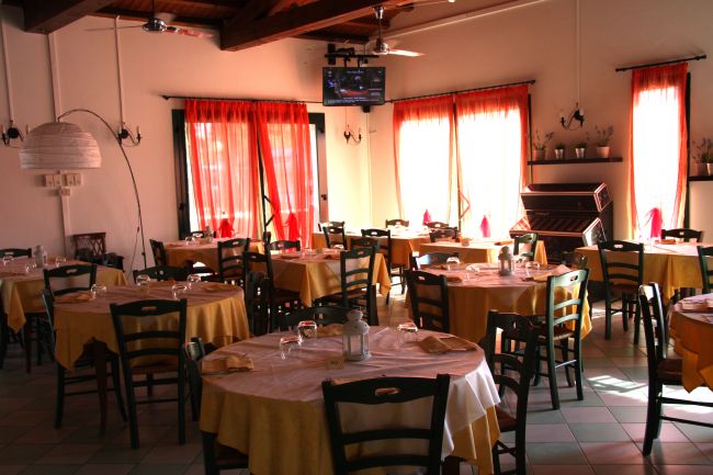 Sala ristorante con tavoli apparecchiati.