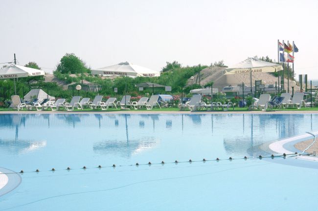Piscina con lettini e ombrelloni.