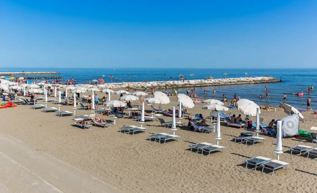 Spiaggia con ombrelloni e lettini.