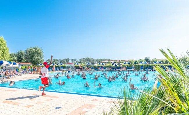 Piscina affollata con istruttore in azione.